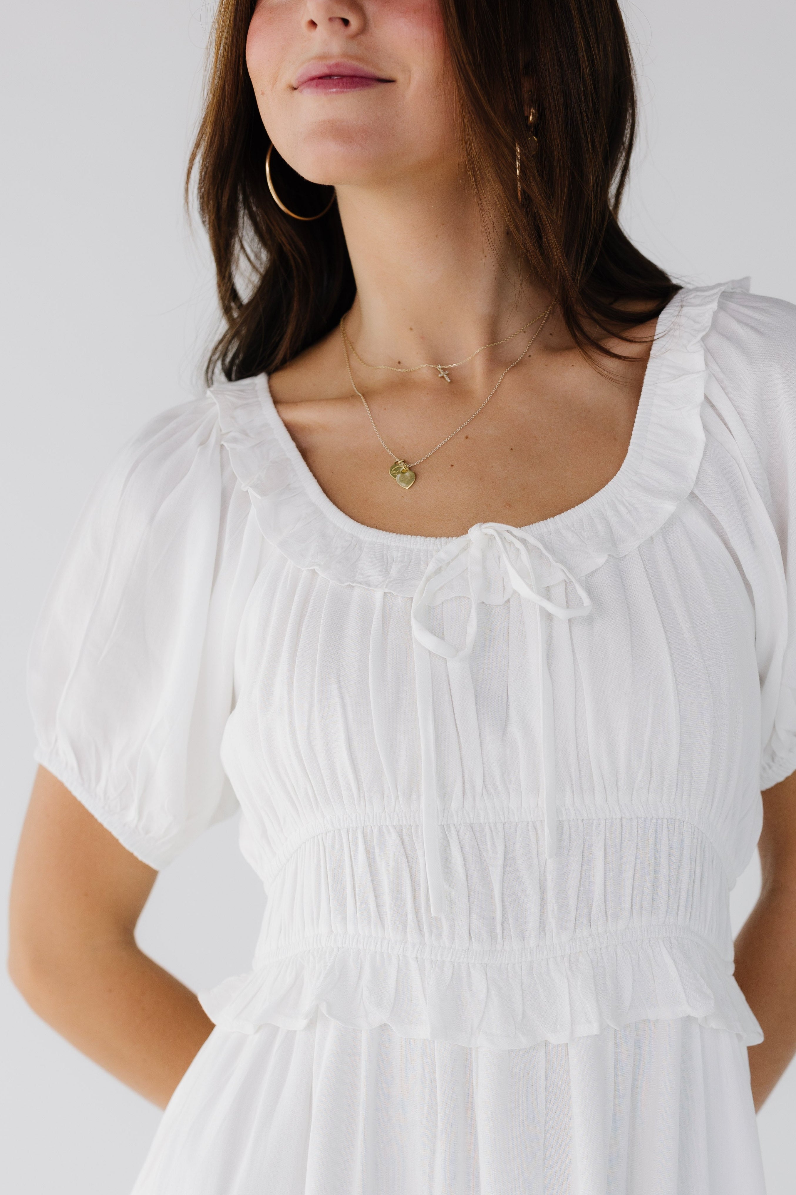 Close_view_of_a_woman_wearing_a_white_scoop_neck_dress_with_a_wide_elastic_waistband_with_ruffle_details.jpg Citrus Jena Dress