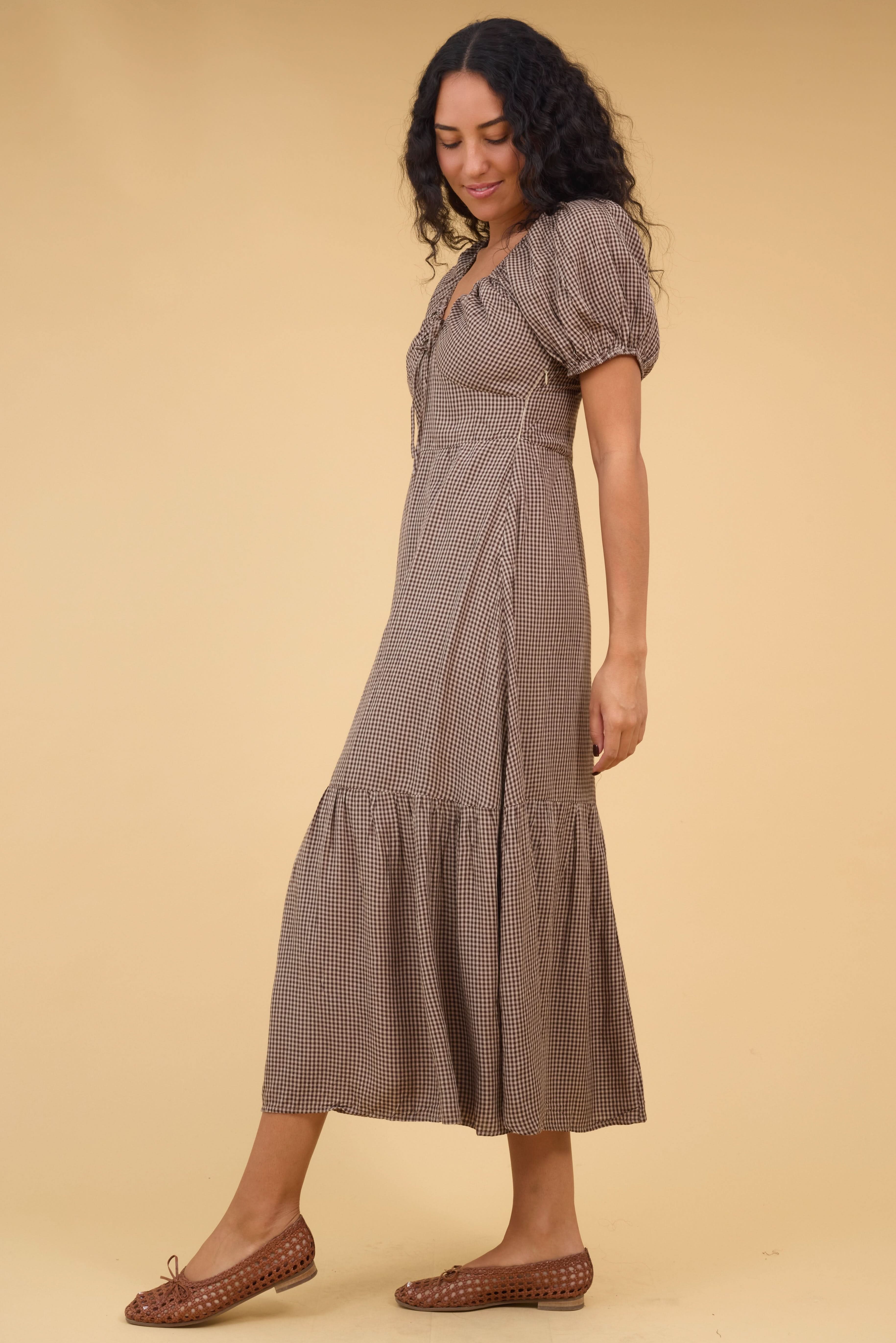 Side_view_of_a_young_woman_wearing_a_brown_gingham_midi_dress_with_short_puff_sleeves_size_zipper.jpg Citrus Alba Dress