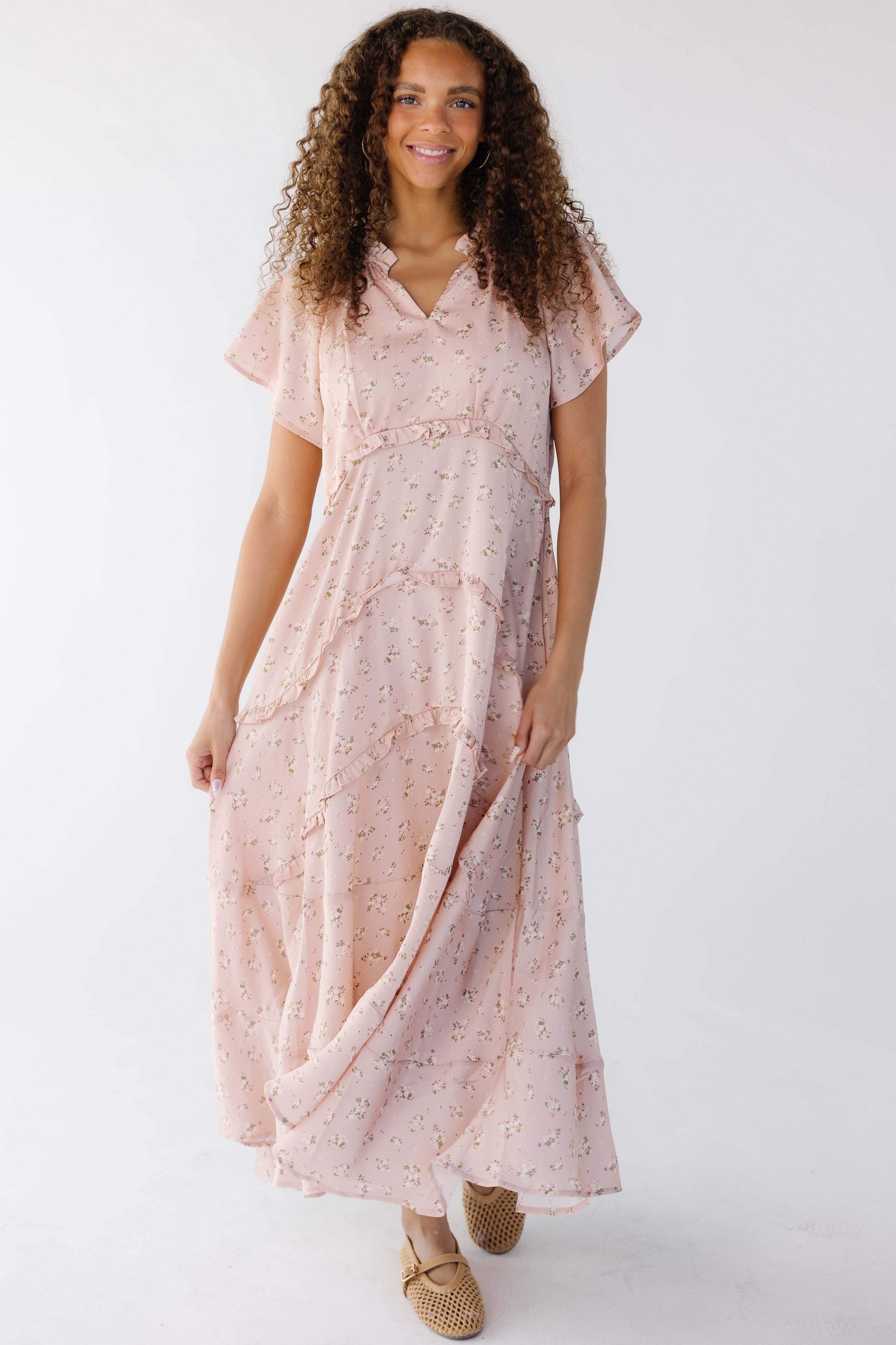 Teenagegirlwearingaloosefittingpinkfloralmaxidresswithnarrowrufflesbetweenthetiersandshortsleeves.jpg Brass & Roe Kelsey Maxi Dress
