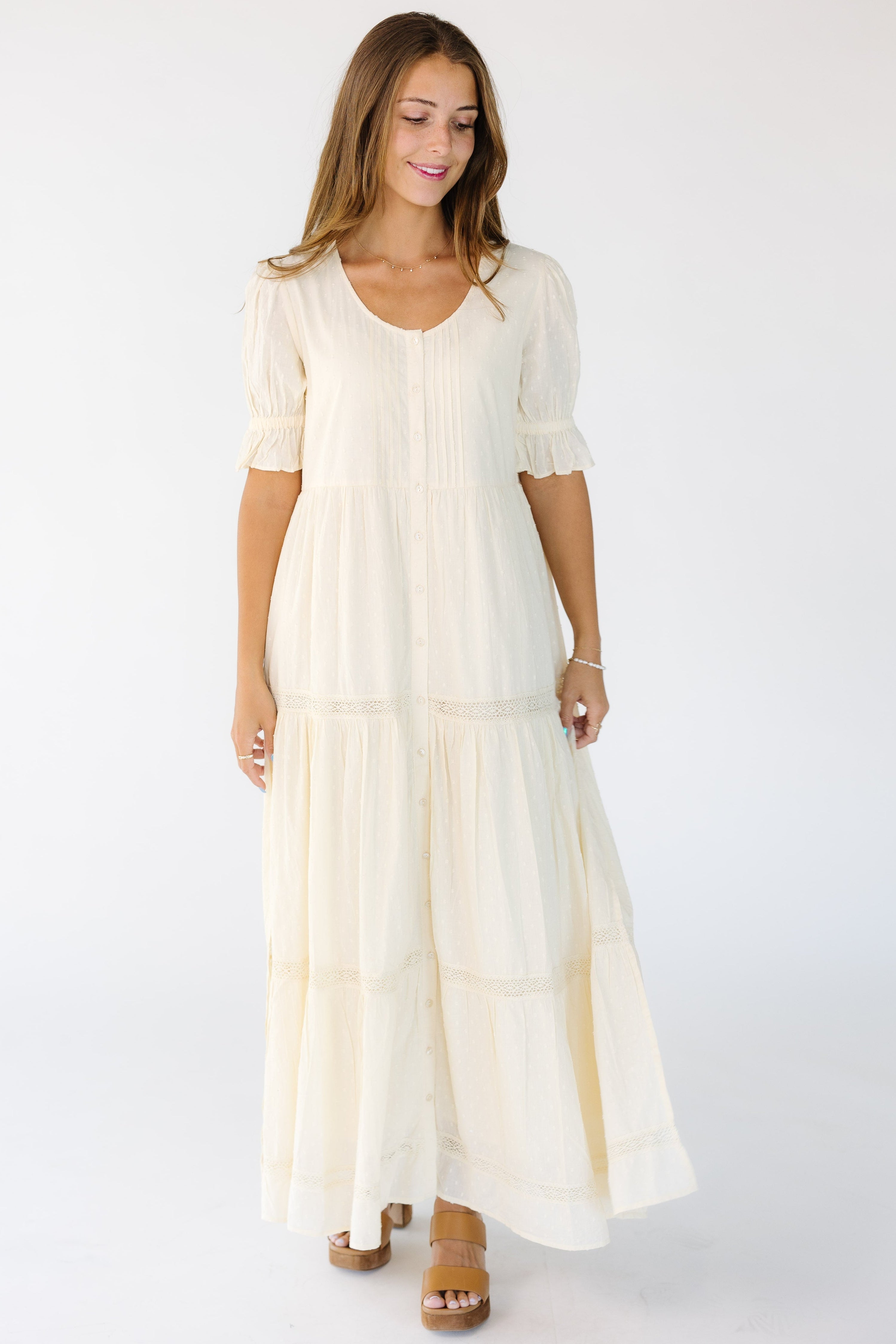 Womanwearingacreambuttondownmidi-maxidressthatisloosefitingwithlacebetweenthetiersandshortsleeves.jpg Citrus Cities Cream Dress