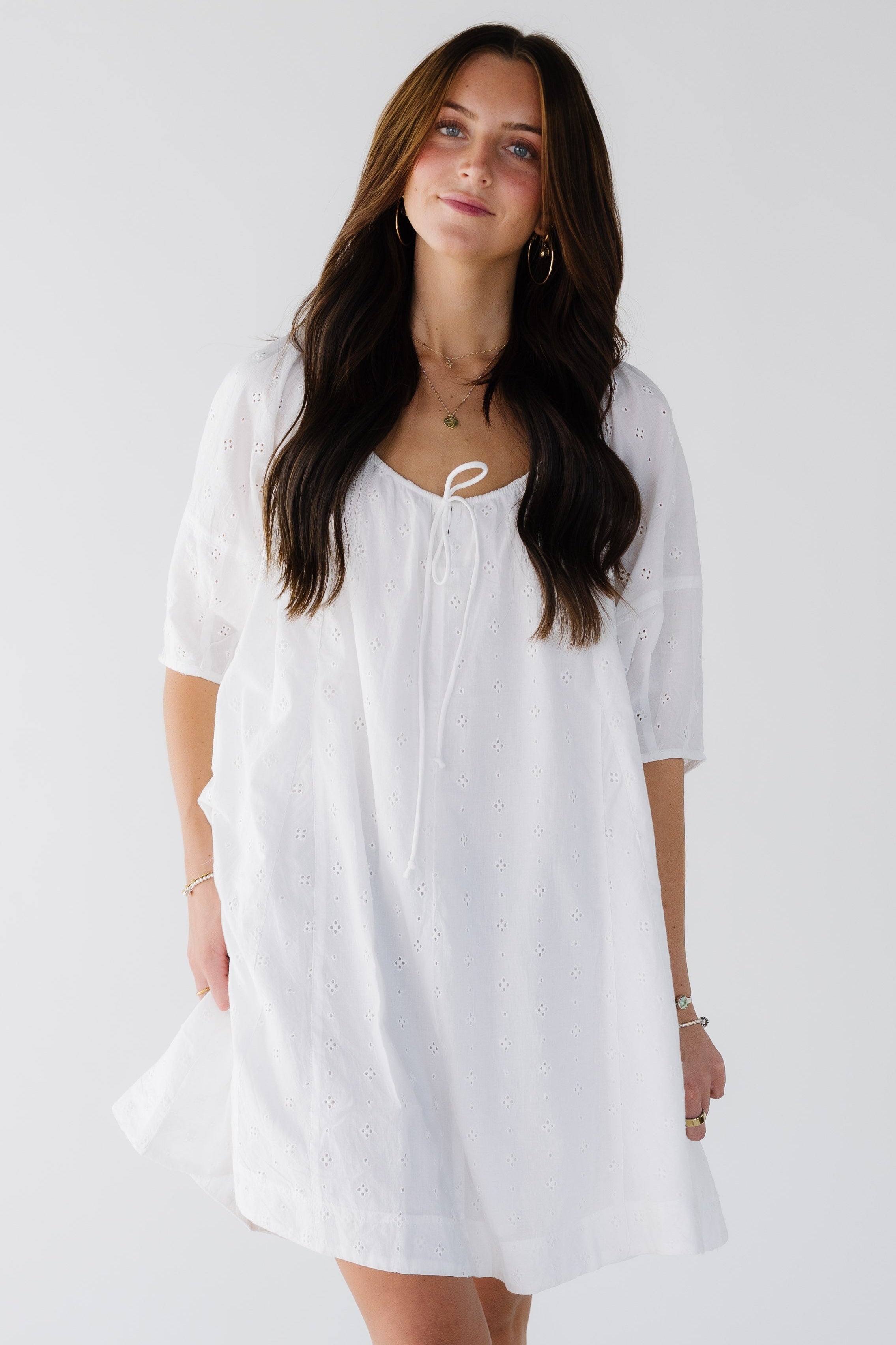 Womanwearingaloosefittingwhiteeyeletshortdresswithhalflengthsleevesandawidedrawstingneckline.jpg Citrus White Shifley Tunic