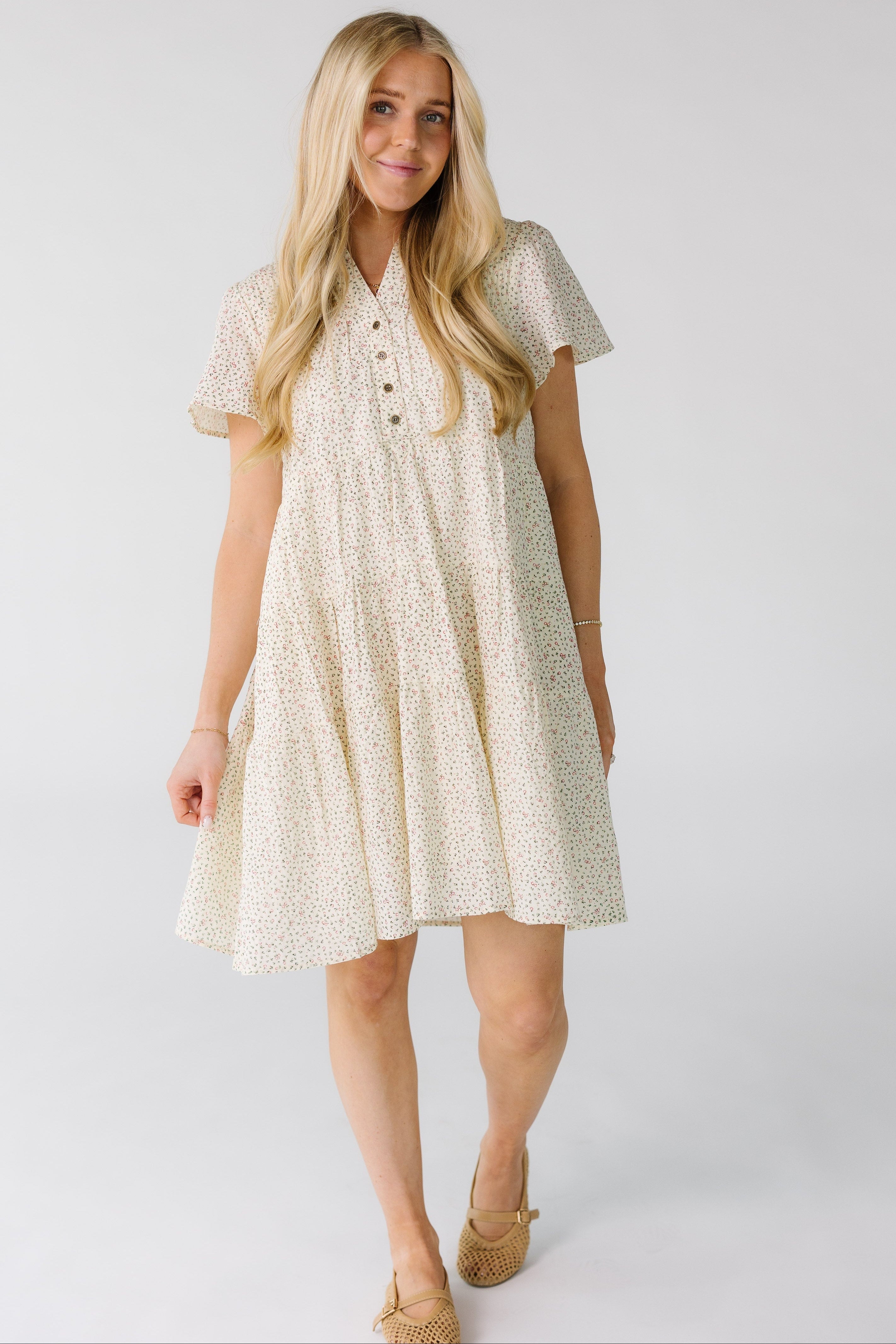 WomanwearingamodestivoryfloralprintmodestdresswithaV-necklineandpointedcollarandshortfluttersleeves.jpg Brass & Roe Emma Details Knee Dress