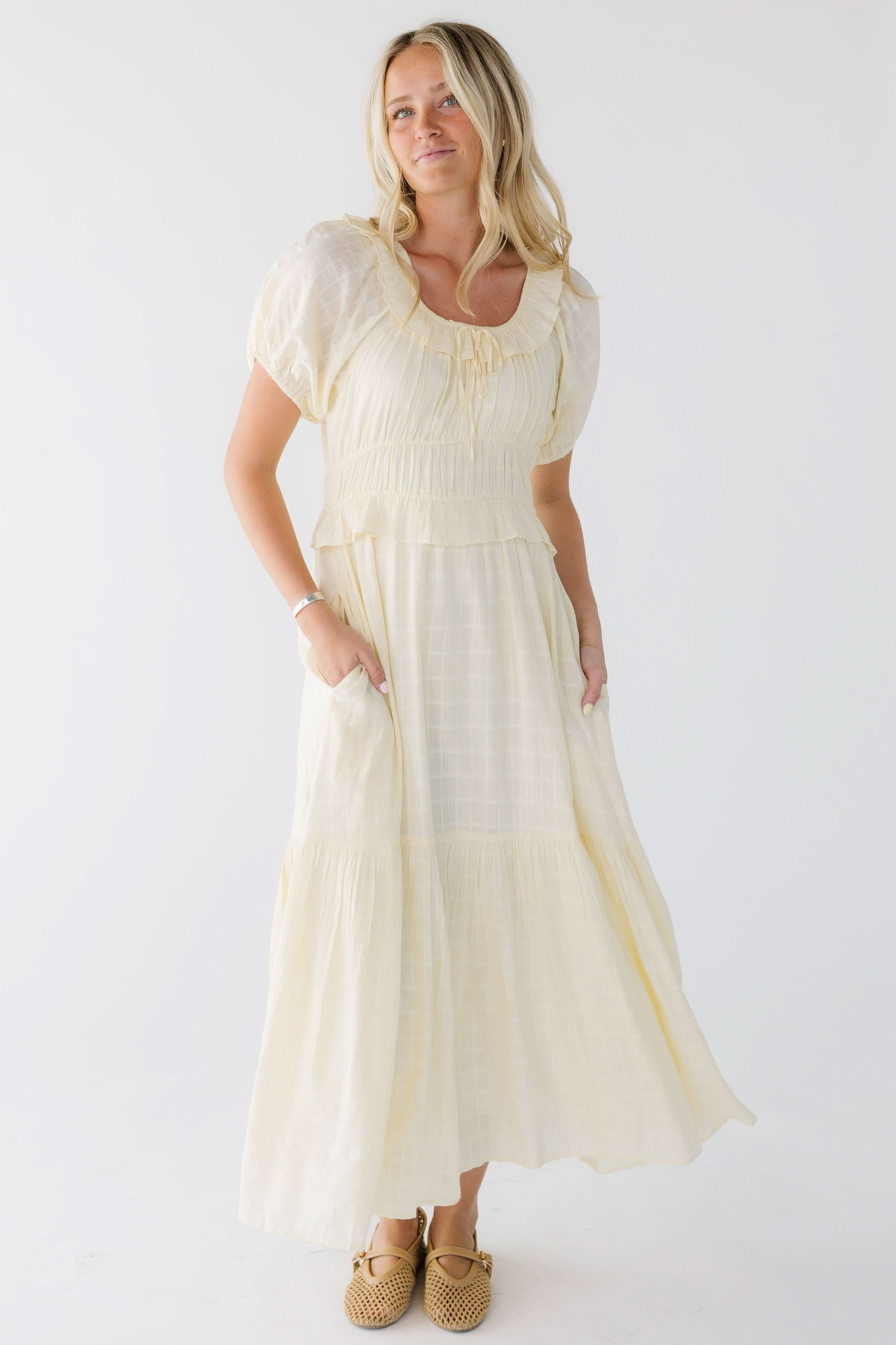 Young_woman_wearing_a_light_yellow_midi_dress_with_a_scoop_neckline_short_puff_sleeves_and_a_wide_close_fitting_waist.jpg Citrus Jena Dress