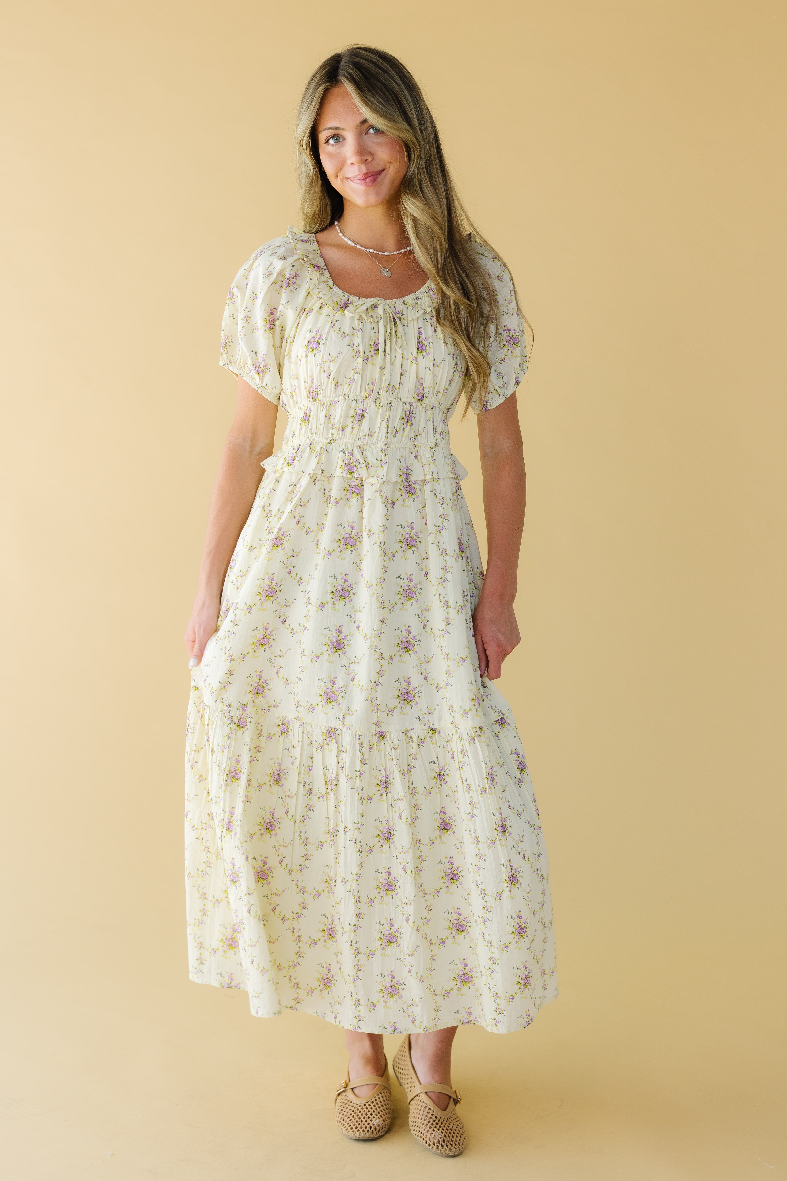 Young_woman_wearing_a_modest_cream_lavender_floral_print_midi-maxi_dress_with_a_wide_scoop_neckline_puff_sleeves_wide_waistband_and_full_skirt.jpg Citrus Jena Dress