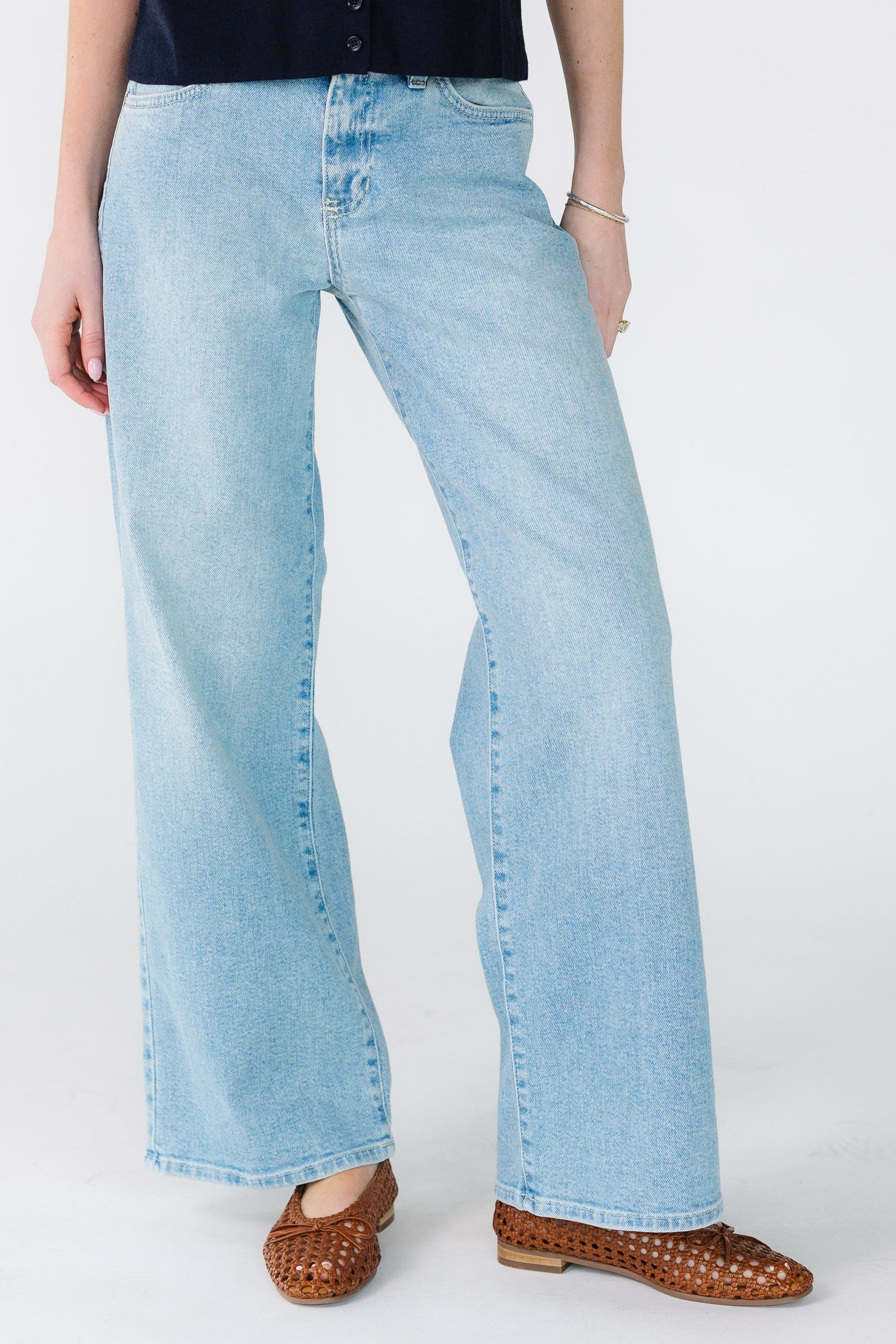Youngwomanwearingapairofmodestlightdenimwidelegjeans.jpg Mid Rise Denim