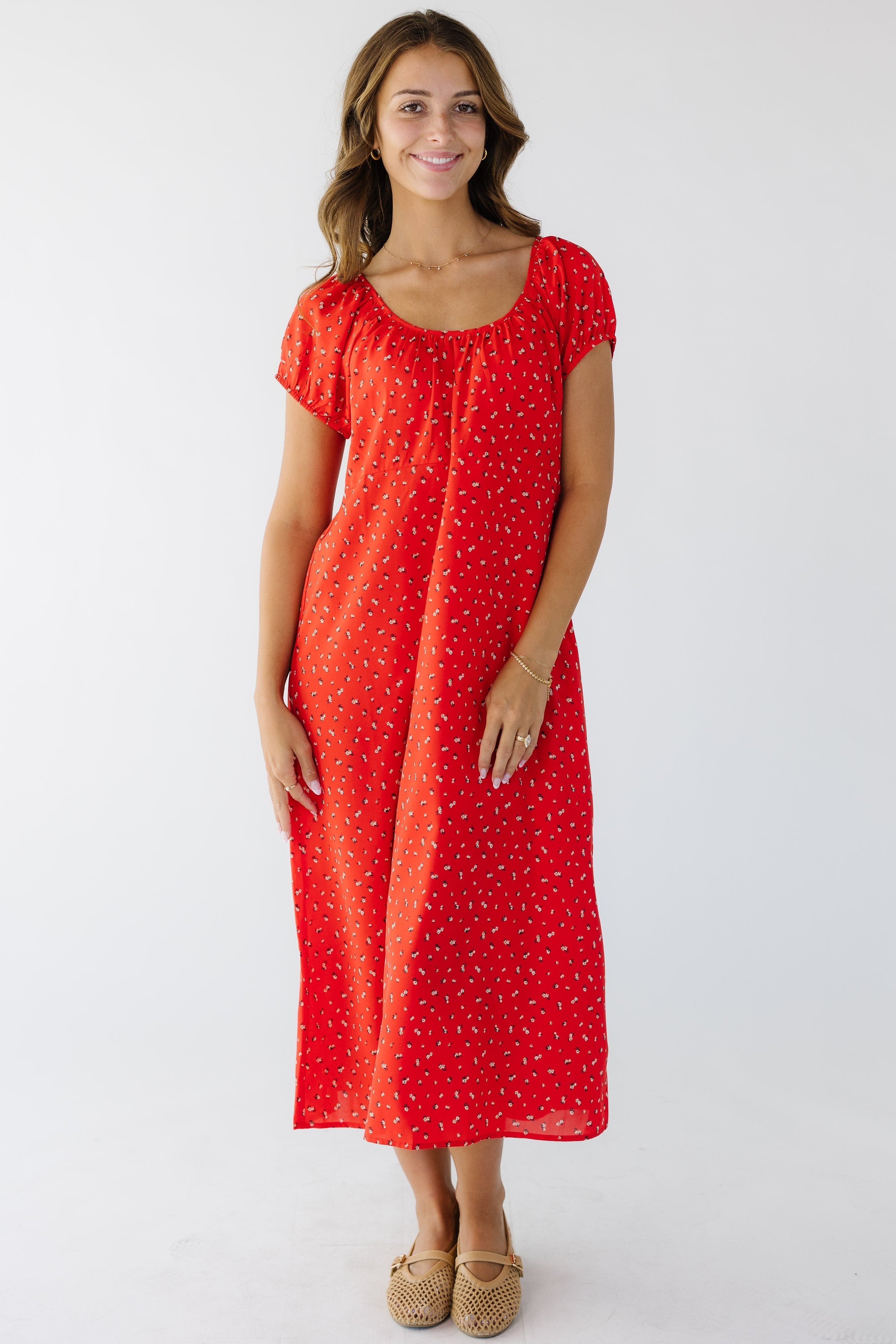 Youngwomanwearingaredfloralmididresswithascoopnecklineandshortpuffsleeves._127d8e51-1be0-4ba8-a146-34538617e425.jpg Brass & Roe The Bell Midi Dress